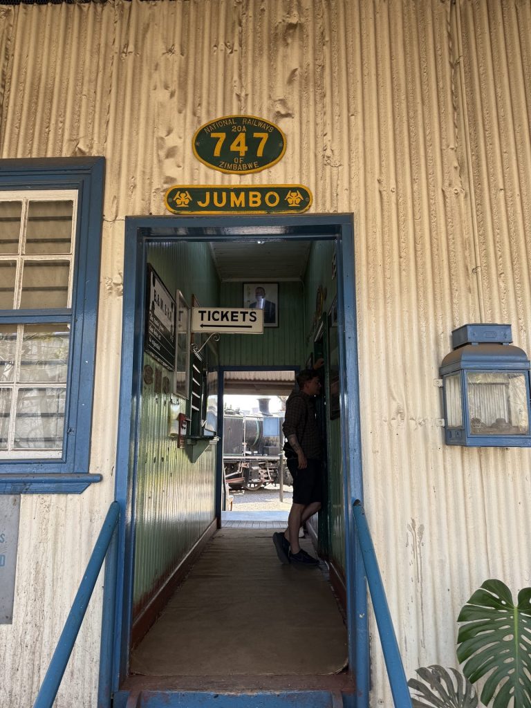 Ticket office doorway at the Bulawayo Railway Museum, steam locomotive beyond