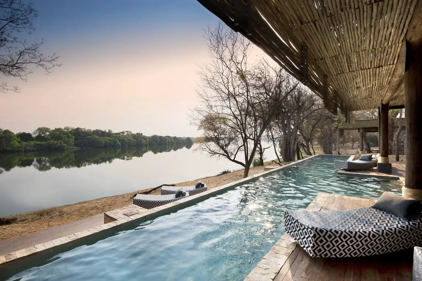 The pool at Matetsi River Lodge looking out over the Zambezi at dusk