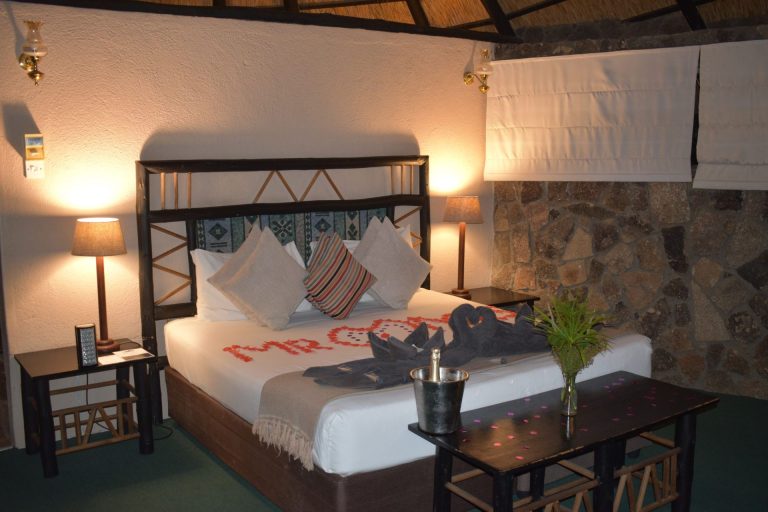 Bedroom at Matobo Hills Lodge with a double bed, mosquito net and special-occasion bed decoration